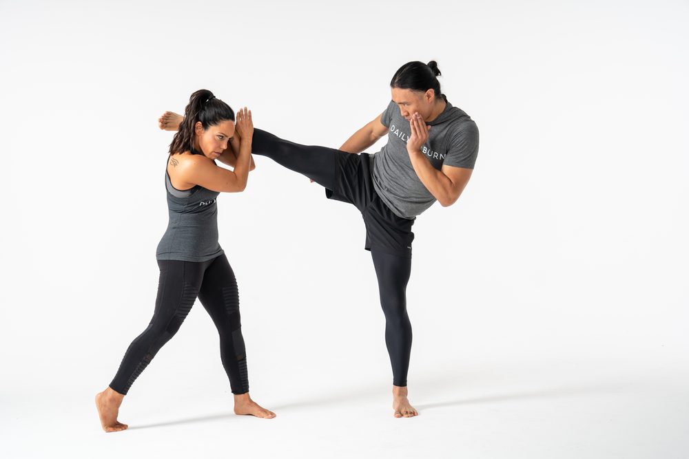Chris throwing a high kick with a training partner on set